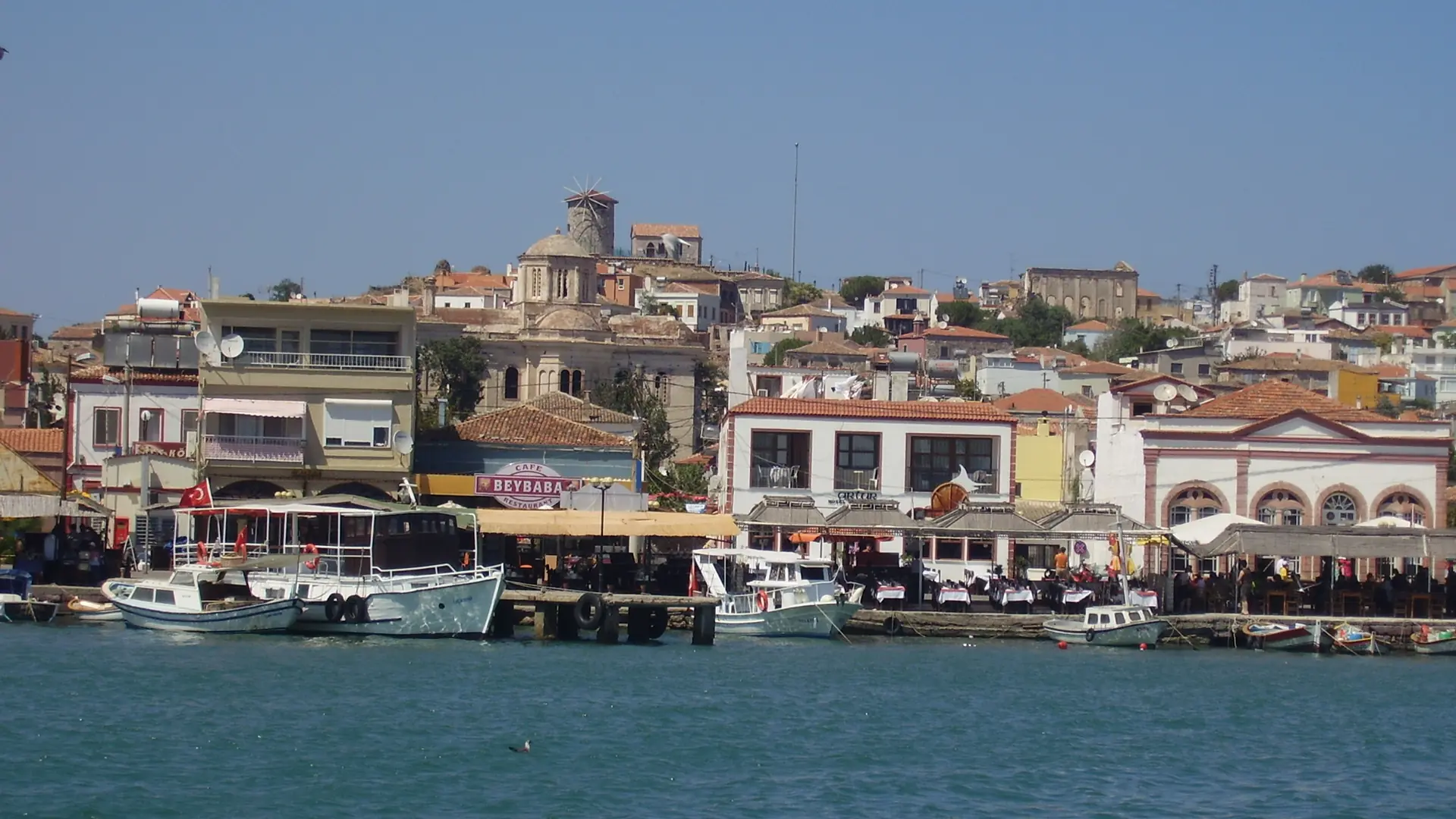 Boats beside Cunda’s historic waterfront and hillside buildings near Ayvalık
