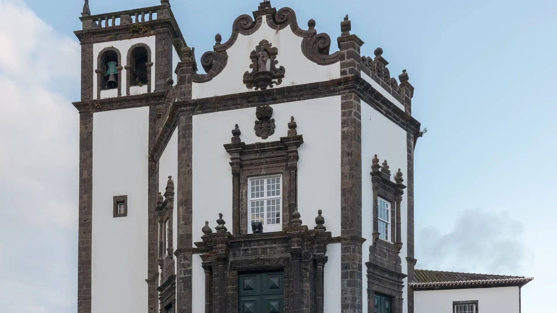the black basalt and white baroque façade of São Pedro Church in Ponta Delgada