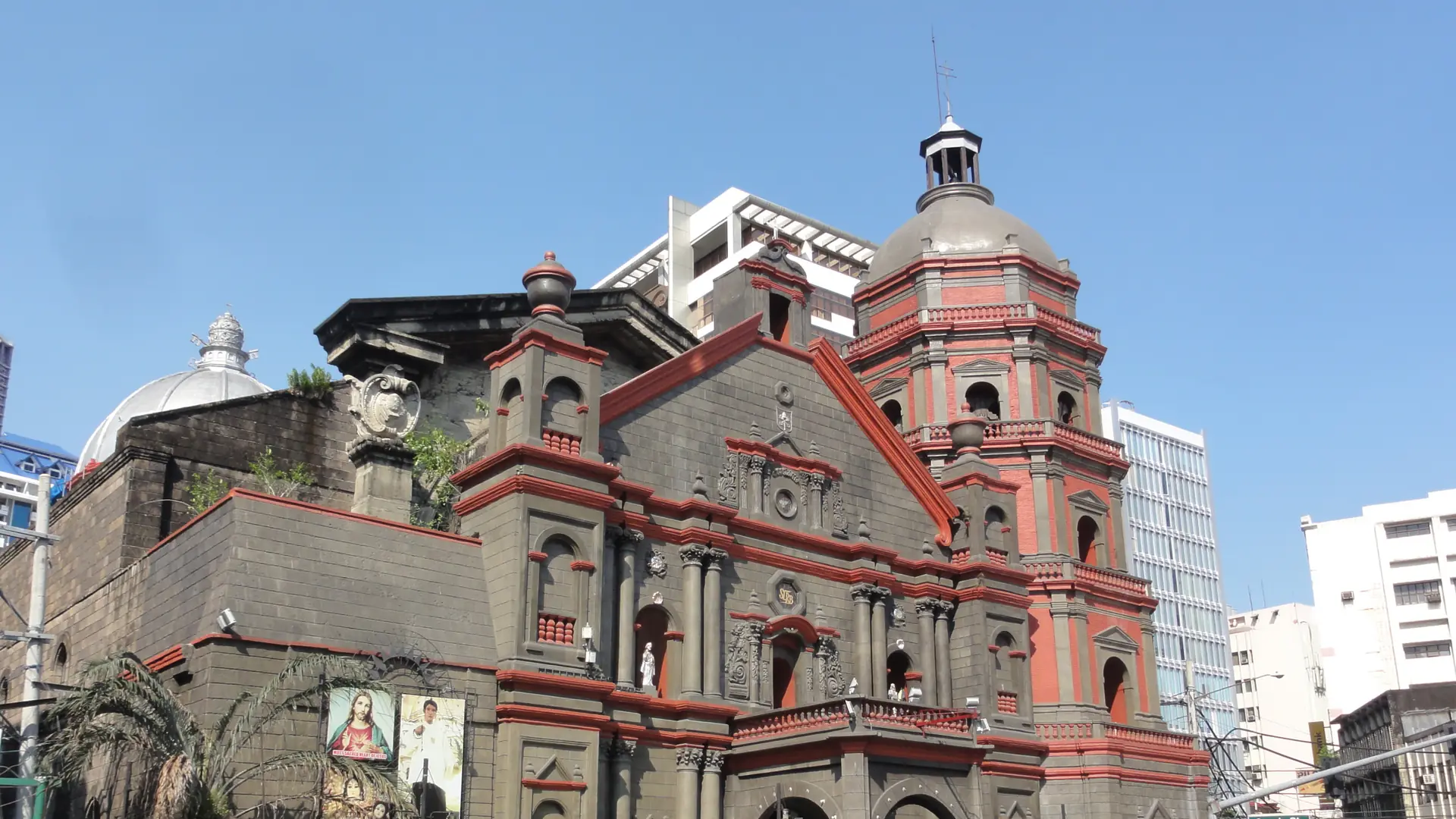The stone facade and bell towers of Binondo Church beneath a blue Manila sky
