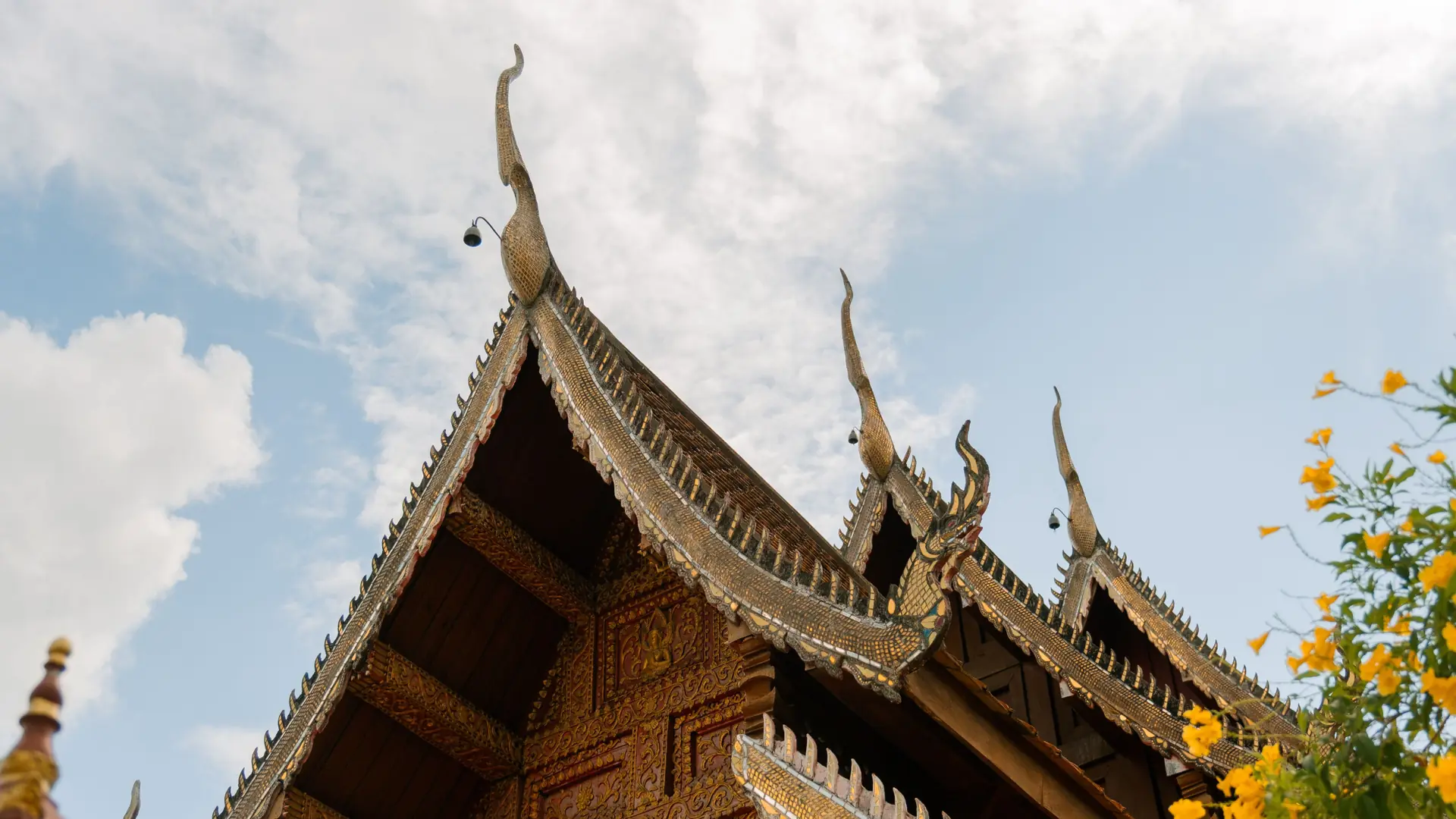 Ornate Lanna-style temple roof beneath a clear Chiang Mai sky
