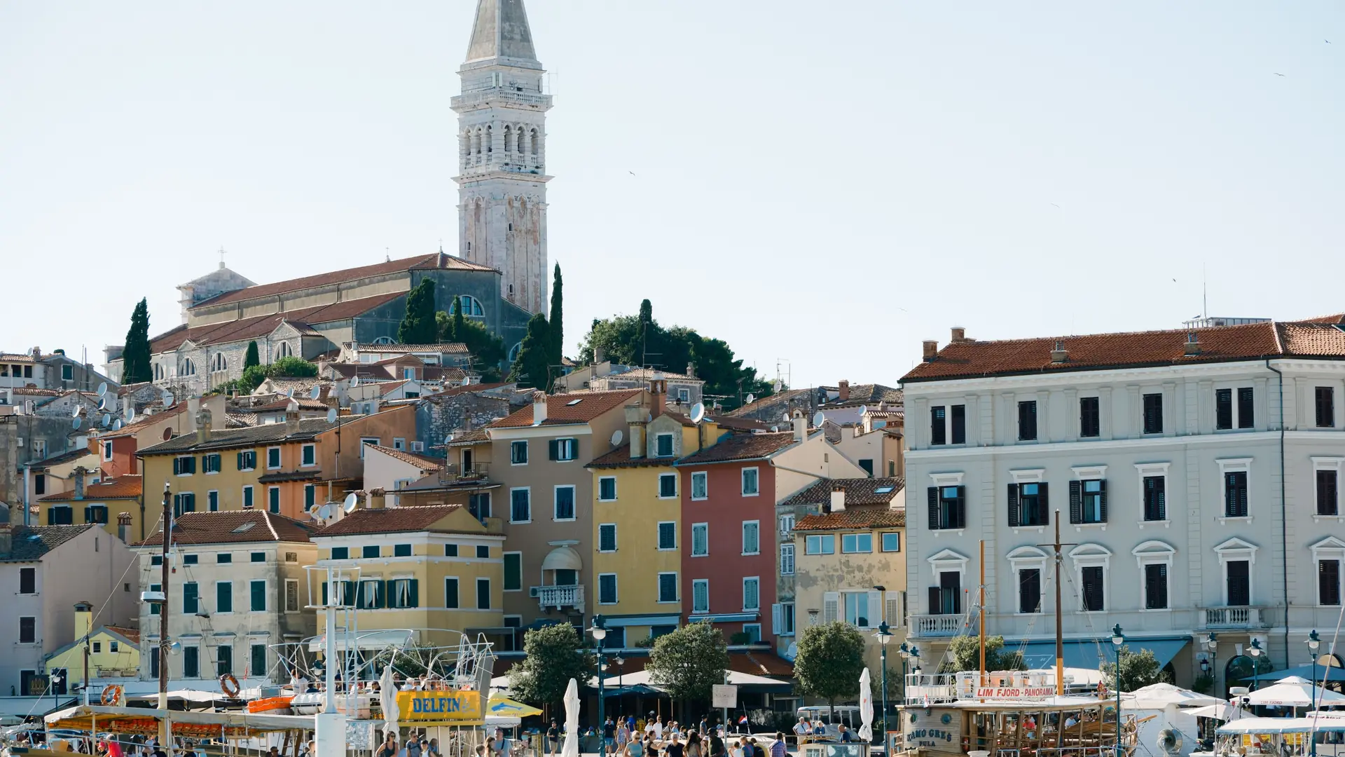 Tour boats moored below Rovinj's waterfront houses and St Euphemia's bell tower
