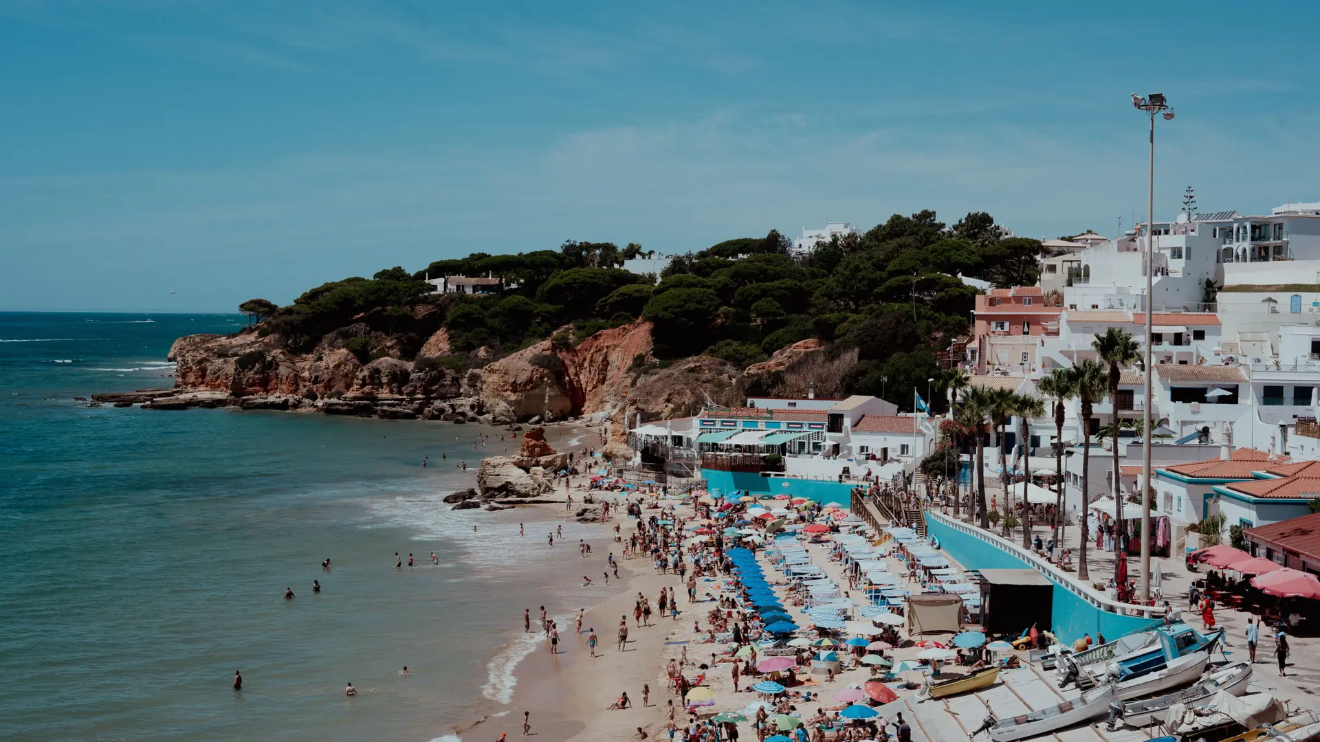 Sunny Albufeira bay with white old town, sandstone cliffs and clear Atlantic water