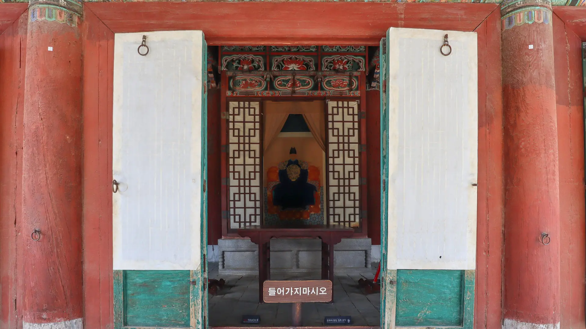 King Taejo's royal portrait visible through the open doors of Gyeonggijeon Shrine's inner hall in Jeonju, in bright daylight