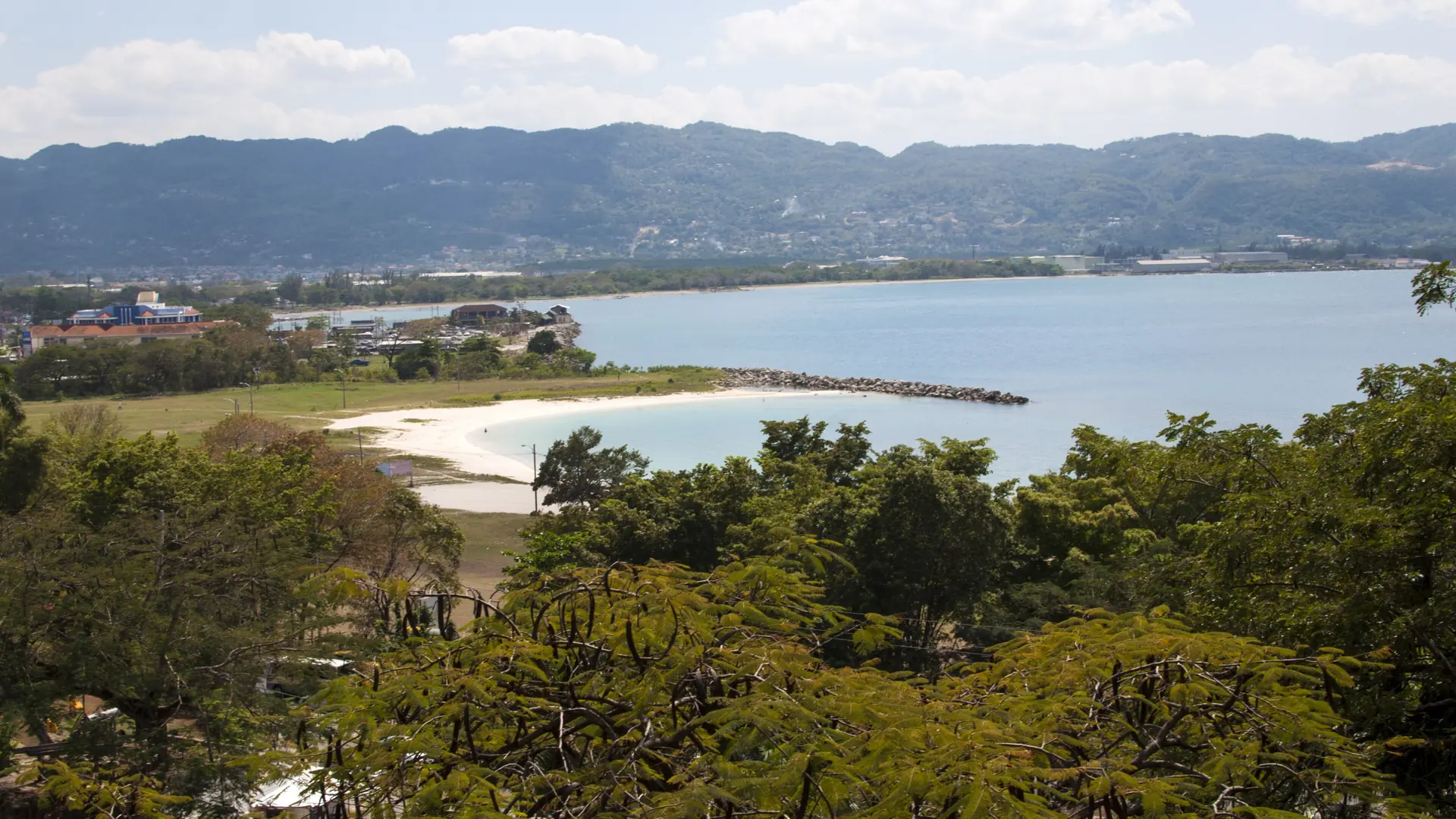 A view over Montego Bay’s beach, coastal water and surrounding hills
