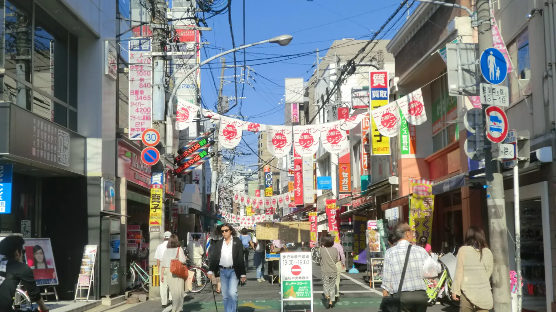 bright Nishijin shopping street in Fukuoka with local storefronts and pedestrians