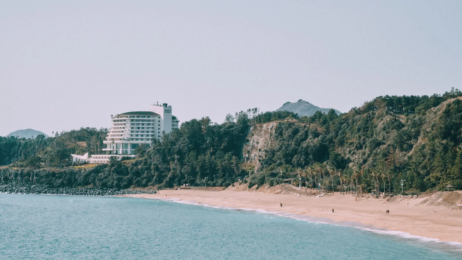 Jungmun Saekdal Beach beneath the resort cliffs on Jeju’s south coast