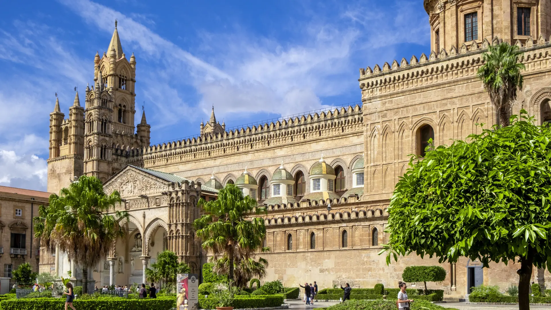 Palermo Cathedral’s south façade and towers above a sunny garden.