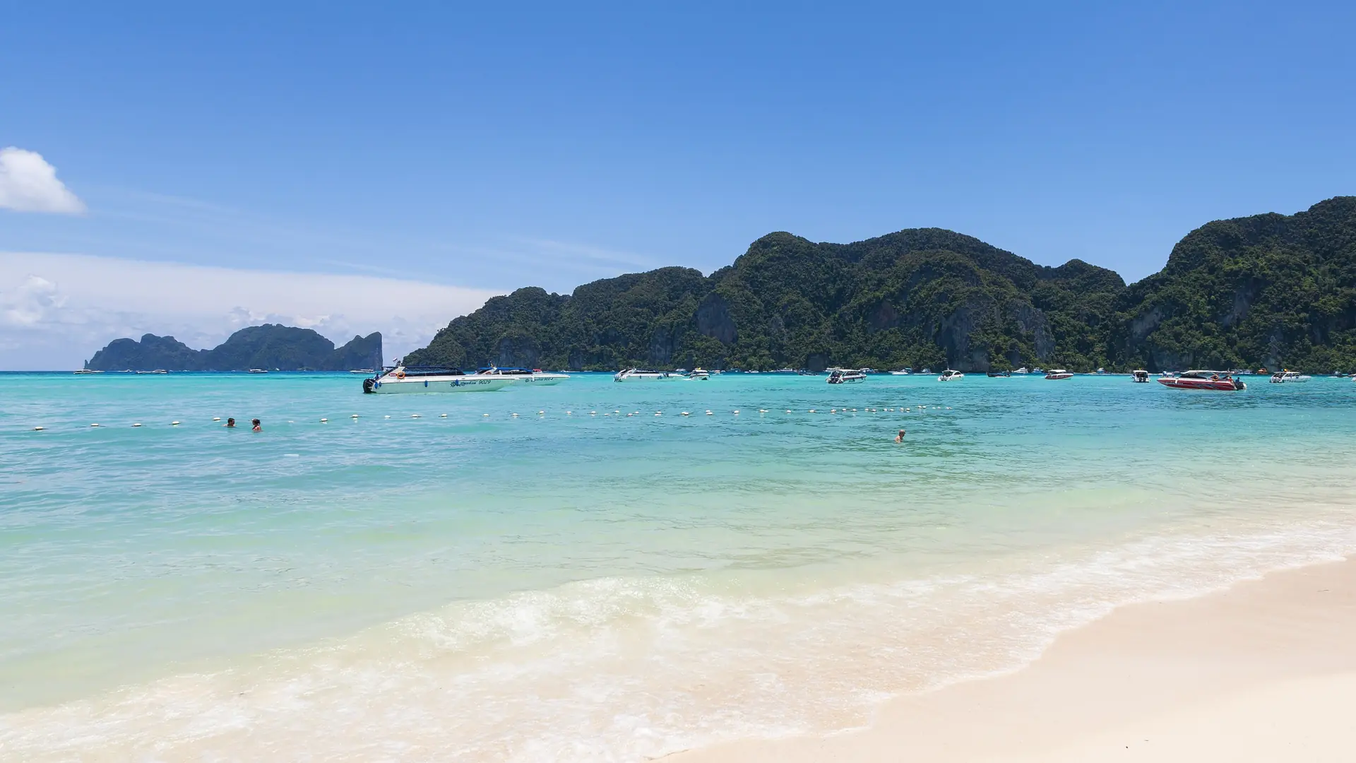 A sunny Phi Phi Don beach facing clear Andaman water