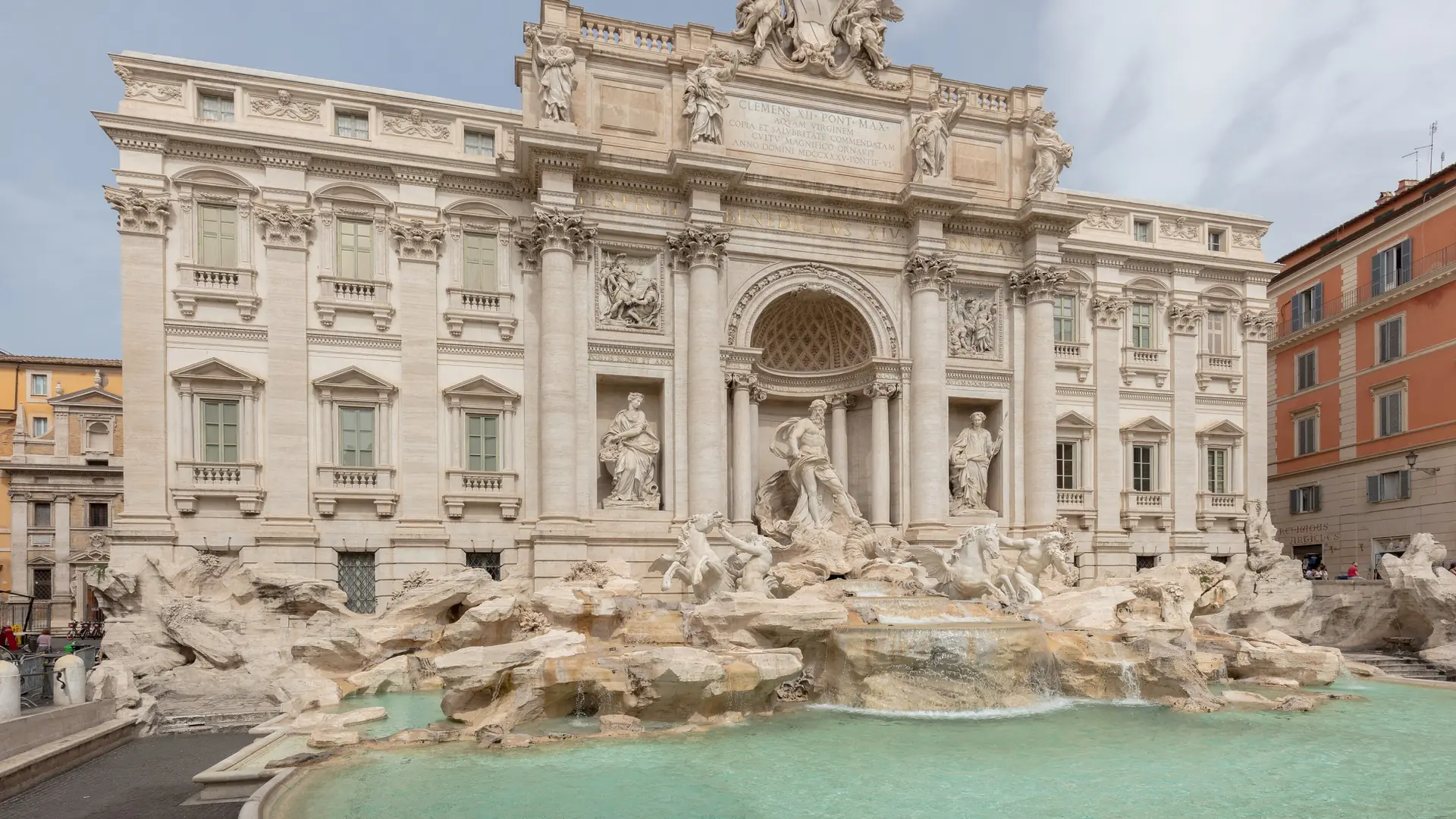 Trevi Fountain’s full marble facade and turquoise pool under a bright sky.