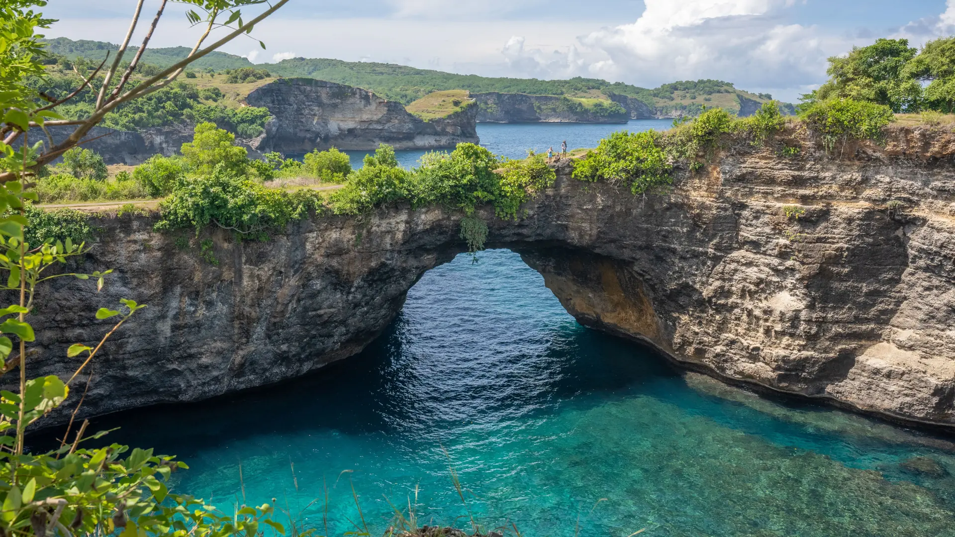 The natural rock arch at Broken Beach above turquoise water on Nusa Penida