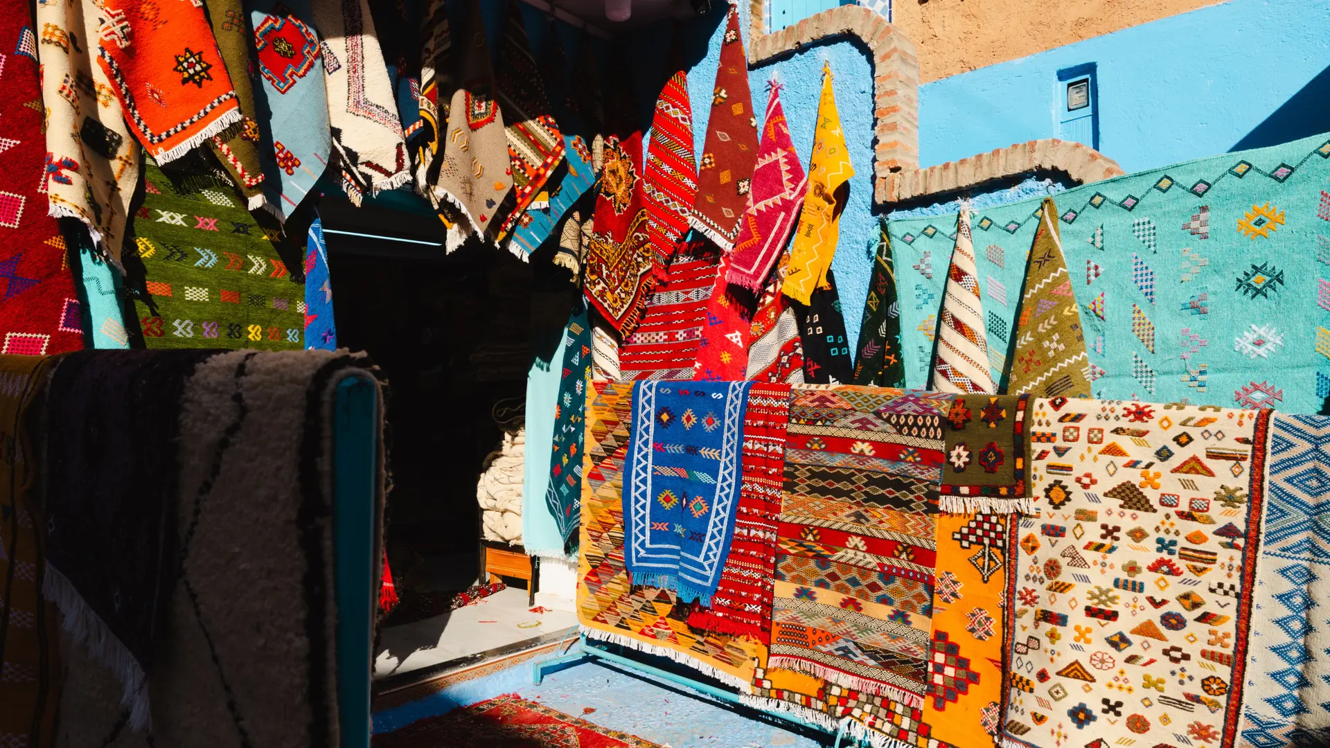 Colourful textiles displayed in Chefchaouen medina market in daylight