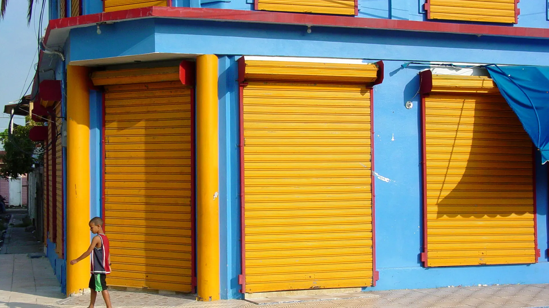 Sunlit blue and yellow painted storefront in Puerto Plata