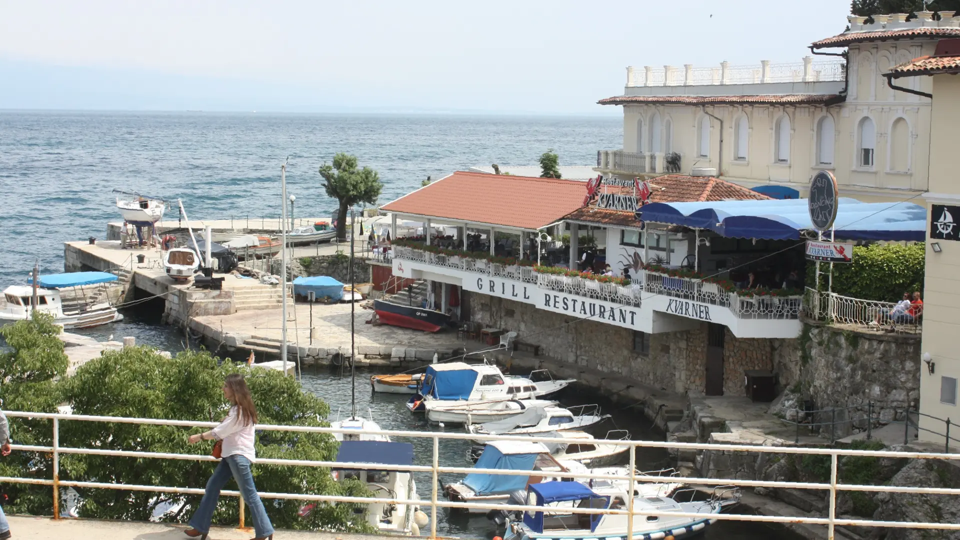 Boats in Lovran’s small harbour beside the waterfront terrace of the Kvarner building