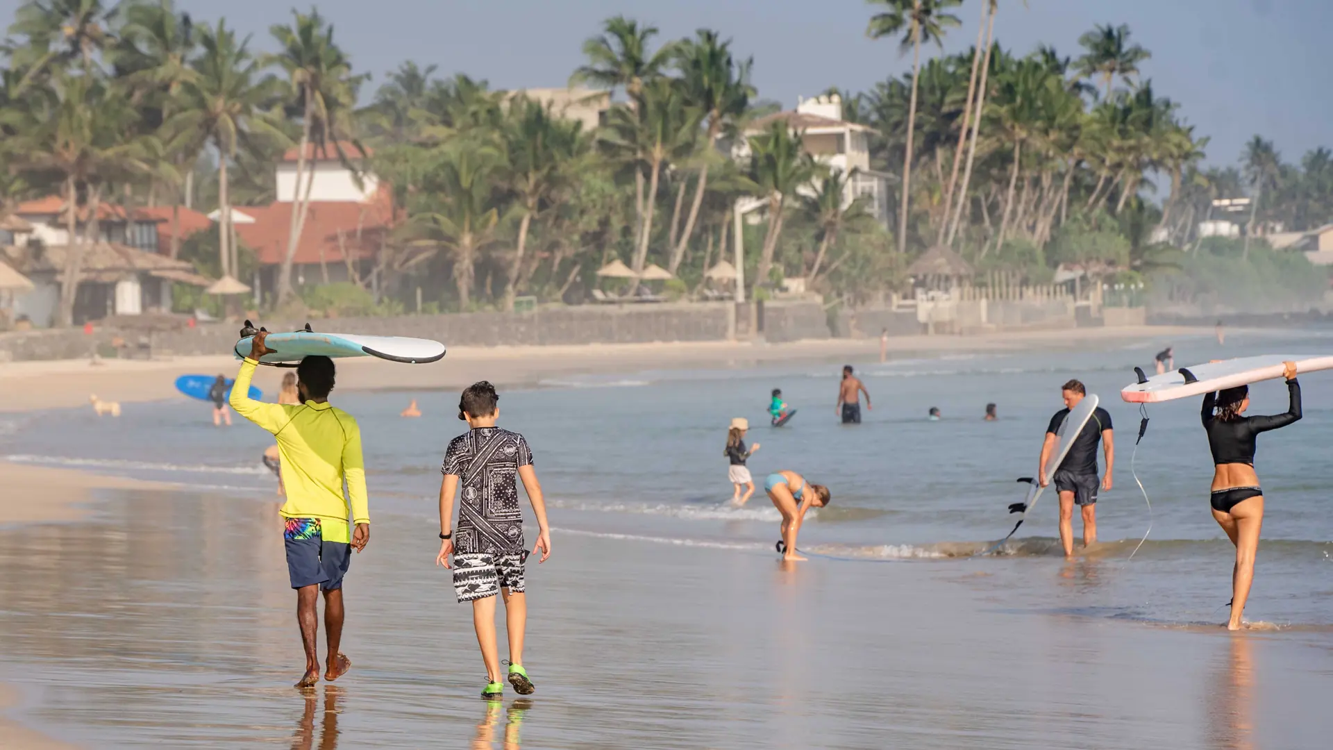 Visitors walking and swimming at Ahangama Beach on Sri Lanka's south coast