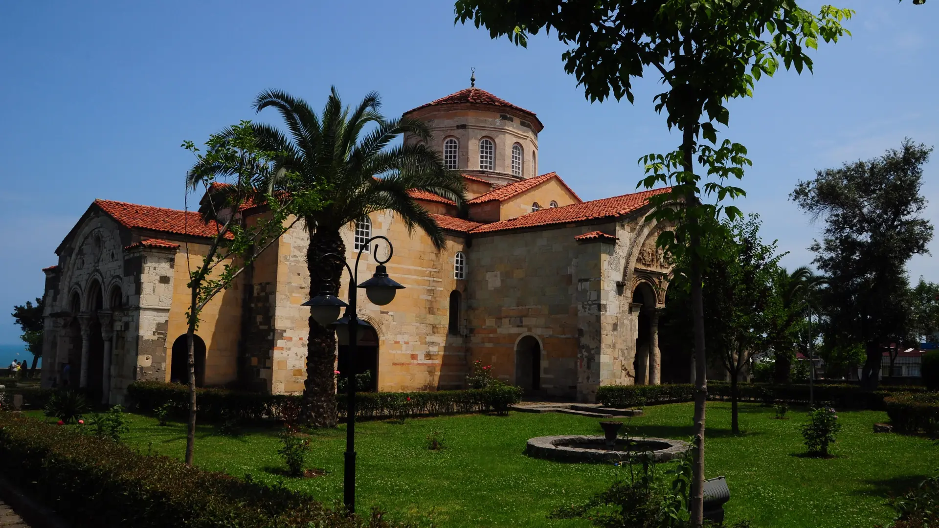 Trabzon Hagia Sophia framed by palms beneath a clear blue sky