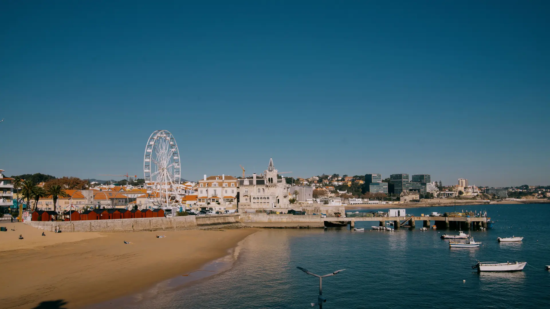 Aerial view of Cascais bay, sandy beach and the historic waterfront beside blue Atlantic water