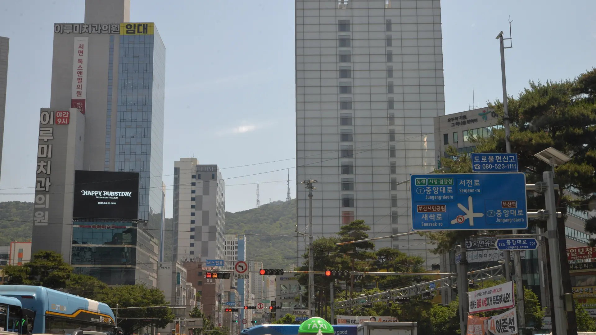 The Seomyeon intersection in Busan, with the Jungang-daero street sign visible amid dense high-rises, in bright daylight