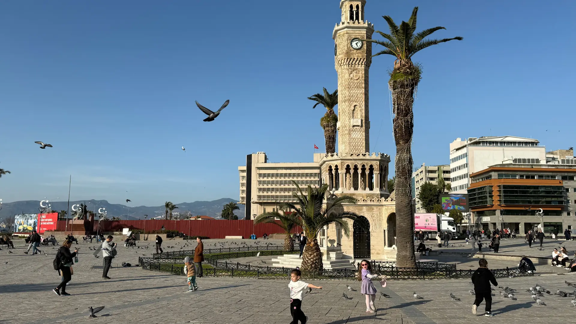 İzmir Clock Tower and Konak waterfront glowing in clear Aegean sunlight beside the blue bay