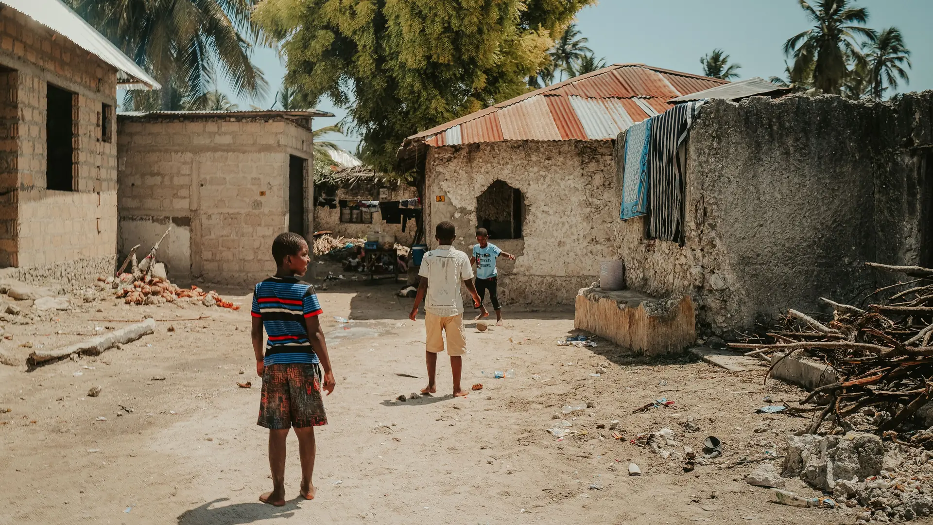 Children in a sandy village courtyard on Zanzibar Island