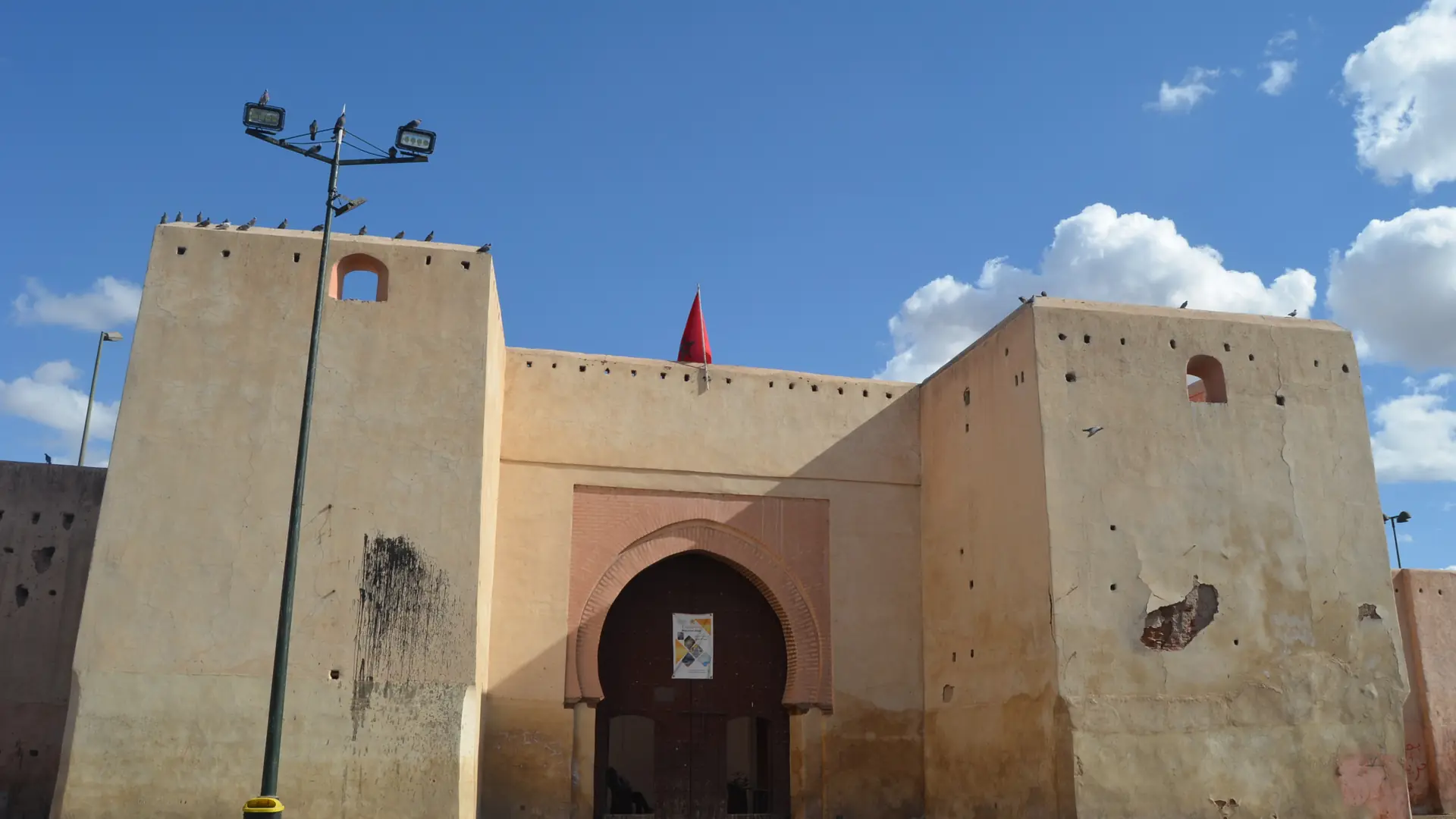 Bab Doukkala gate and its ochre exterior walls under a bright Marrakech sky