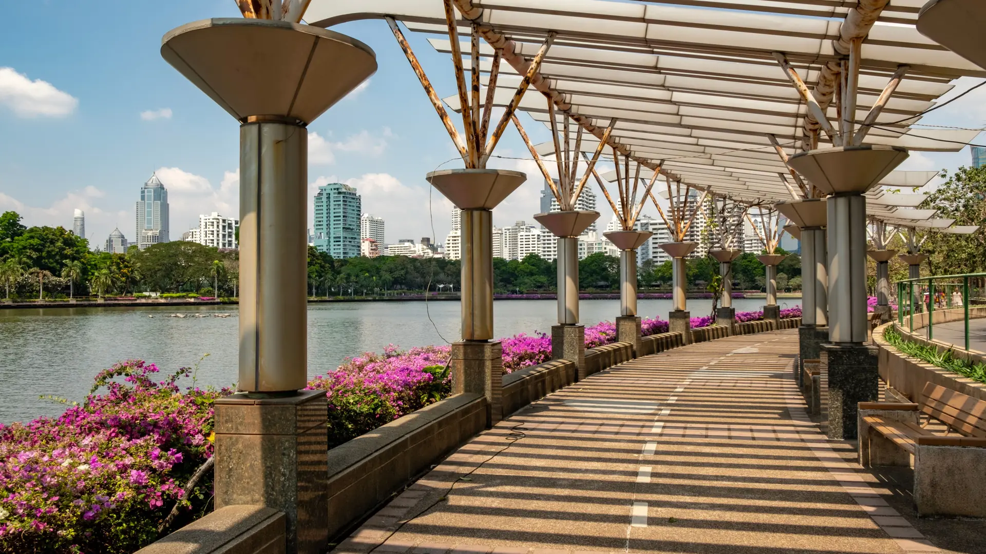 A flower-lined walkway and skyline in Bangkok