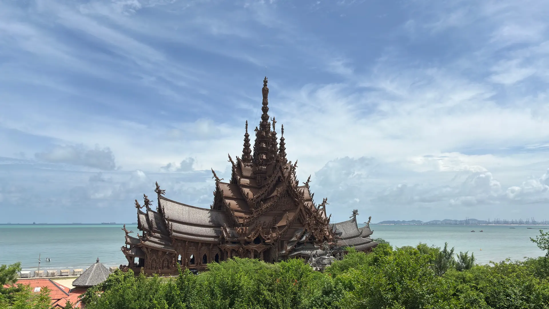 Sanctuary of Truth rising above Pattaya's green shoreline and blue Gulf water