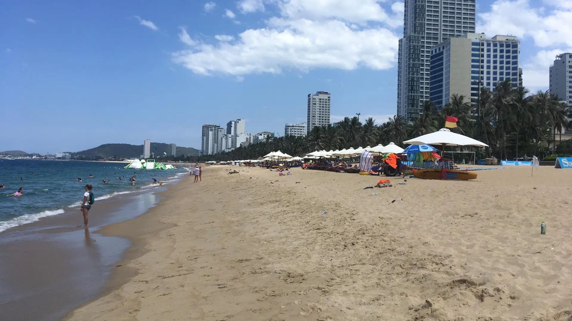 Sun umbrellas on Nha Trang city beach, a wider coastal view