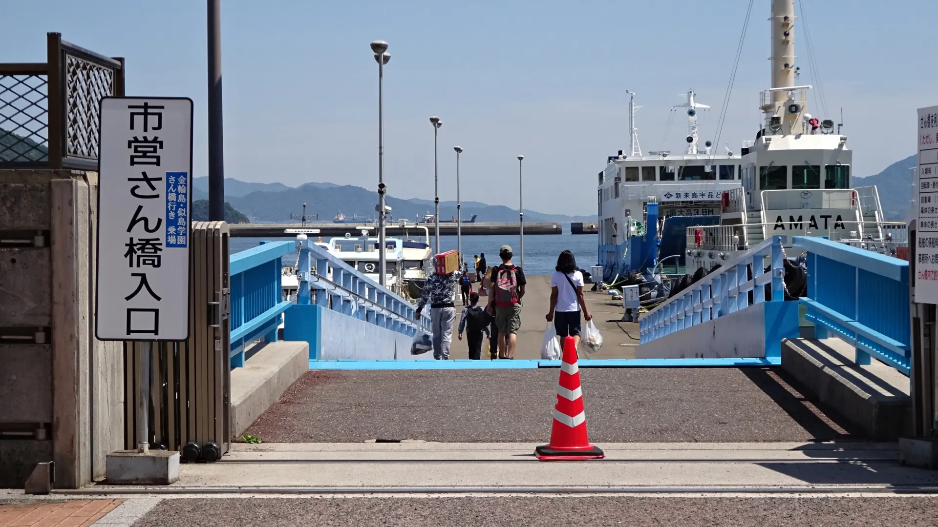 Passengers walking down a blue gangway to ferries at Hiroshima Municipal Pier in Ujina on a sunny day