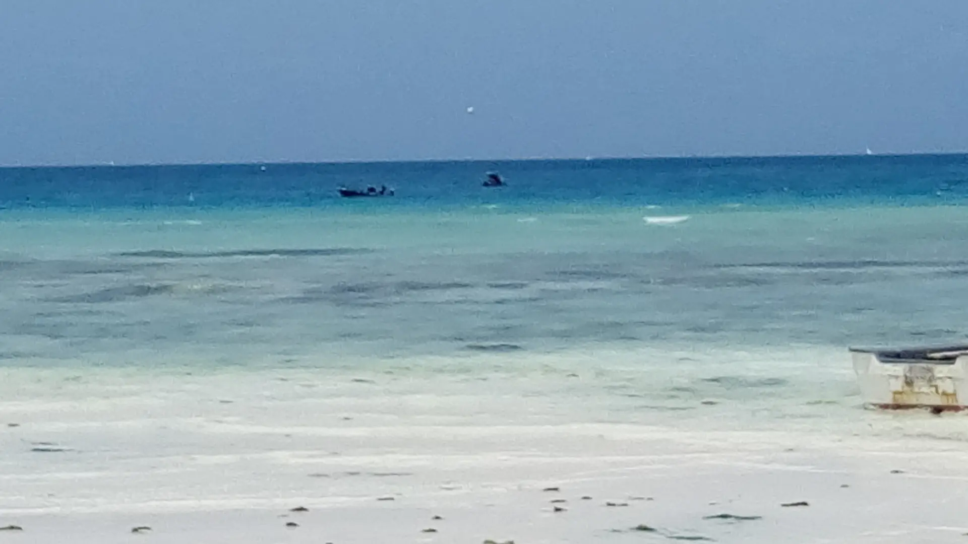 Sunny Nungwi shoreline with pale sand, turquoise sea and boats