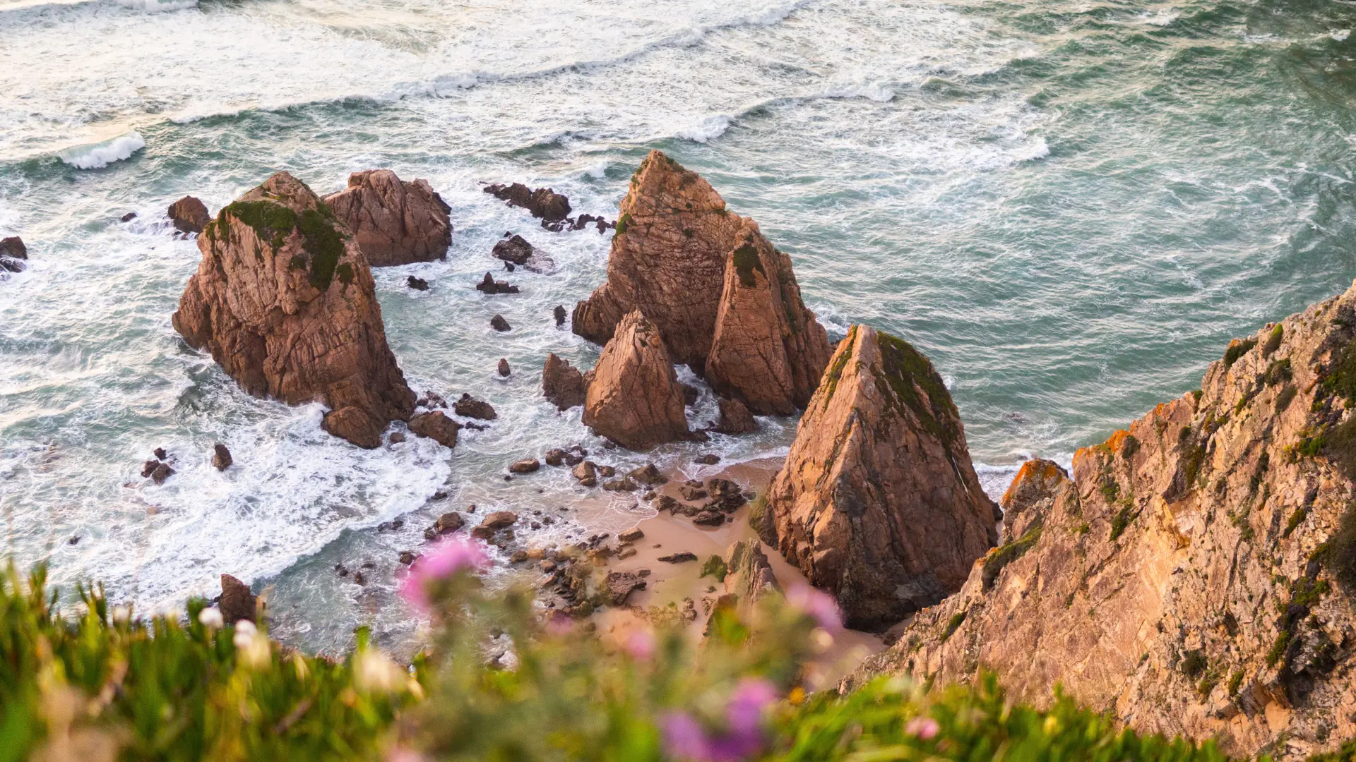 Jagged sea stacks and Atlantic waves at Praia da Ursa on the Sintra coast