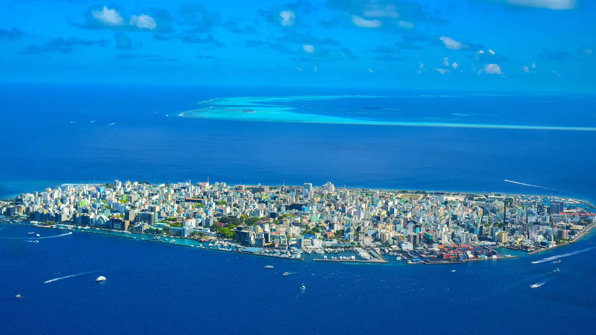Sunlit waterfront and colourful buildings in Malé city beside the Indian Ocean