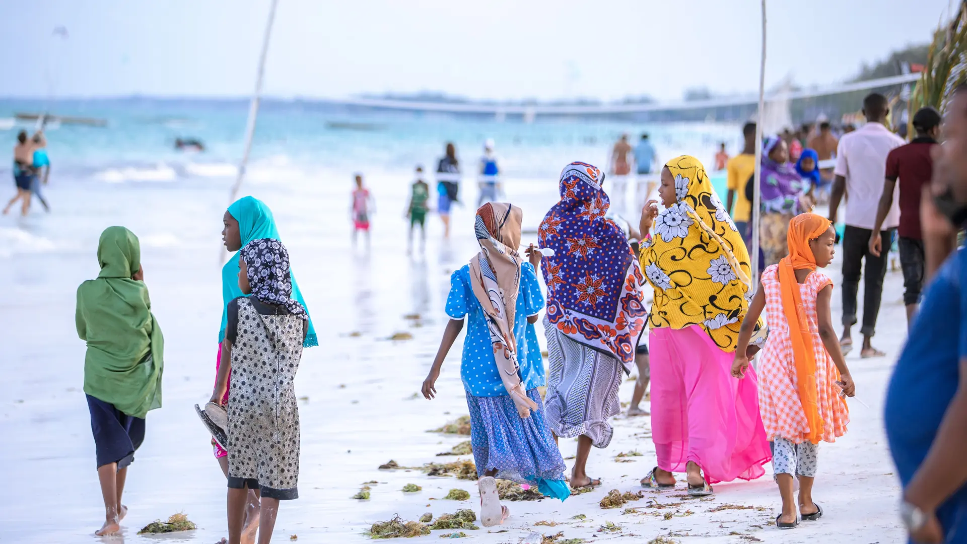 Women in colourful dress walking beside the sea in southern Unguja, Zanzibar
