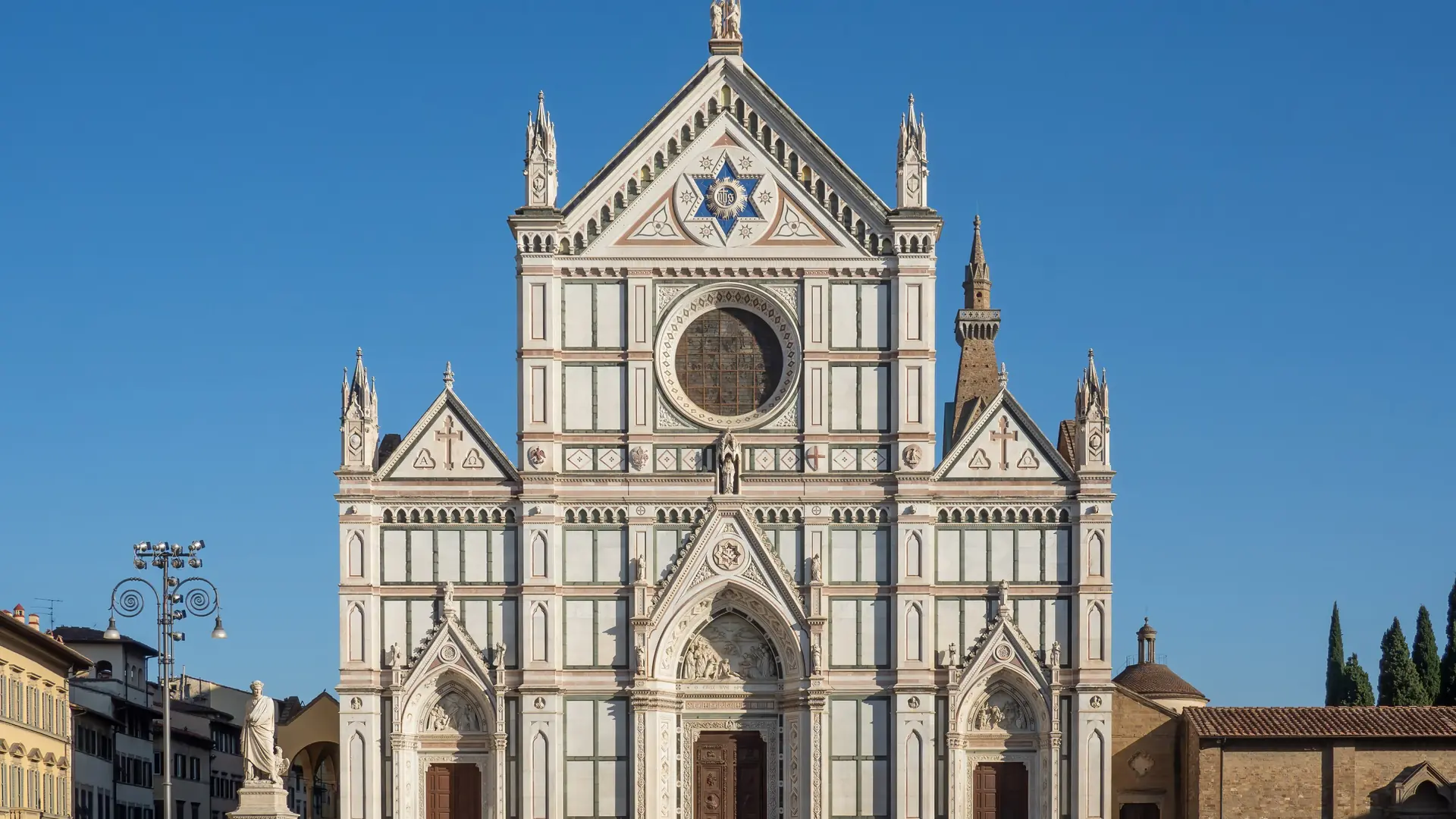 warm stone façade of Santa Croce with nearby market streets and café tables in Florence