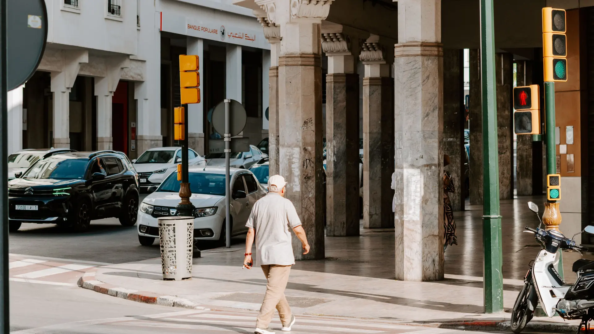 Pedestrian crossing beside arcaded buildings on a Rabat street