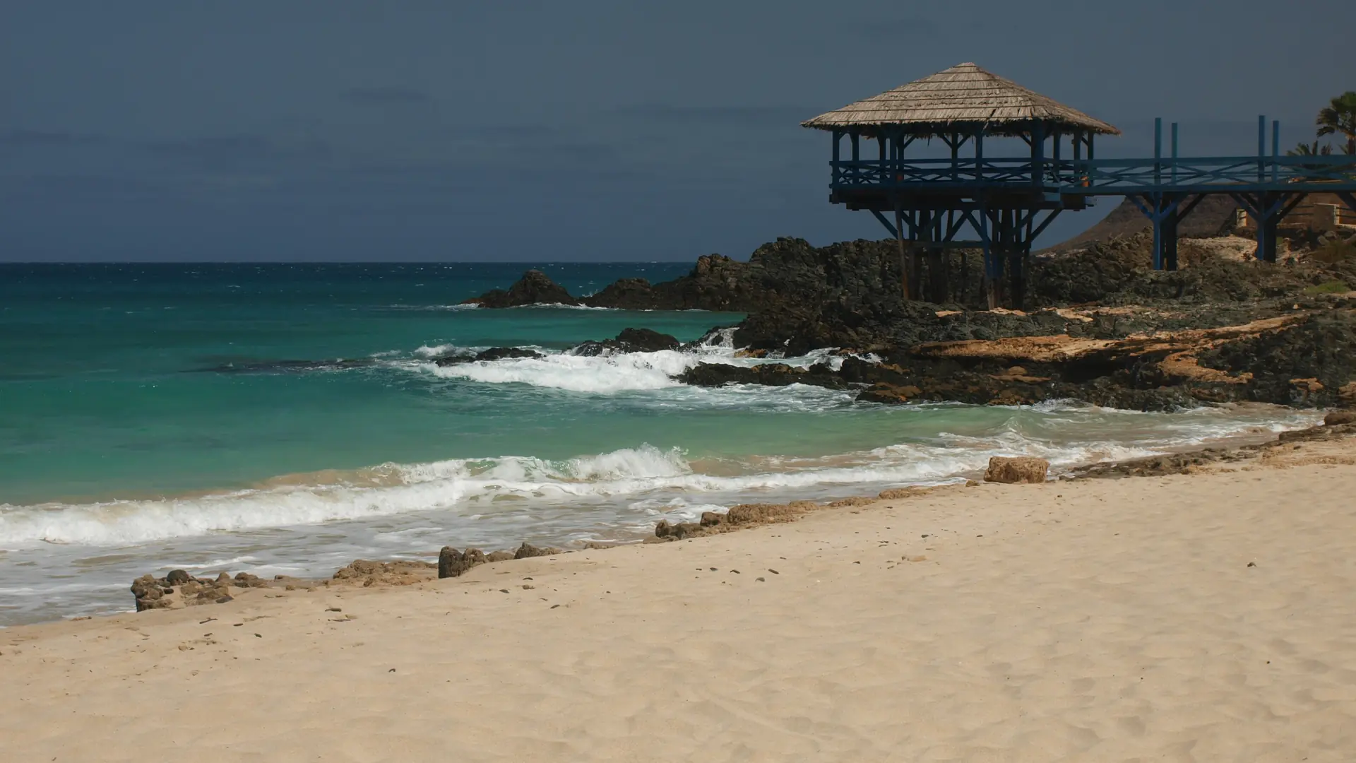 Pale sand and rocky turquoise shore at Praia de Cabral, Boa Vista