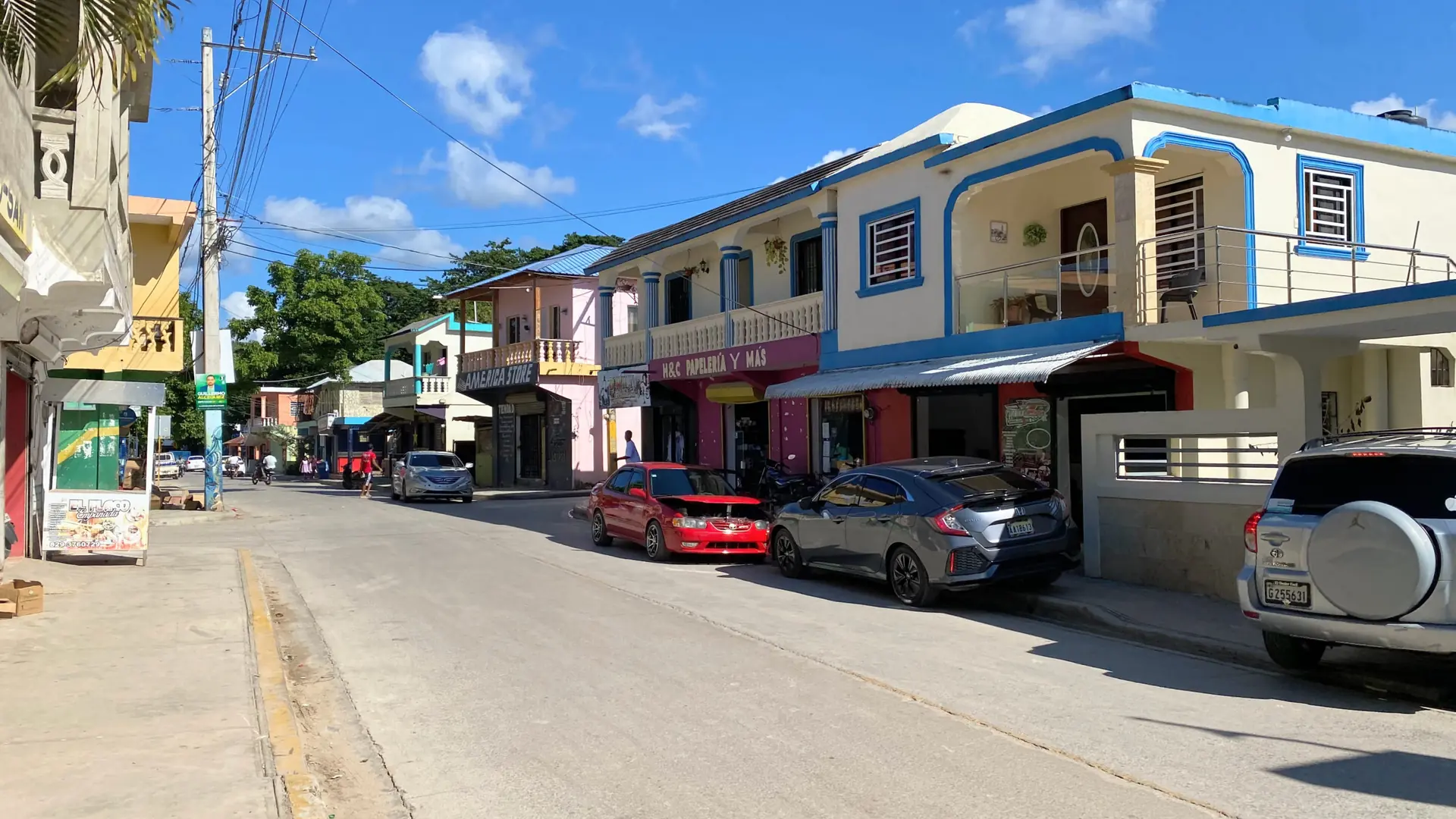 Sunlit shops and colourful buildings on a central Santa Bárbara de Samaná street