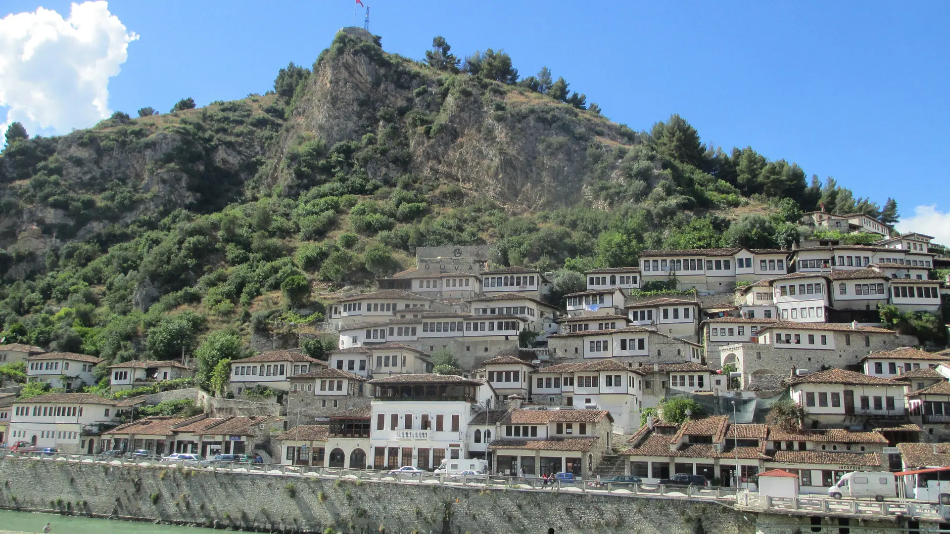 White houses of Berat's Mangalem quarter climbing the hill below the castle in sunshine