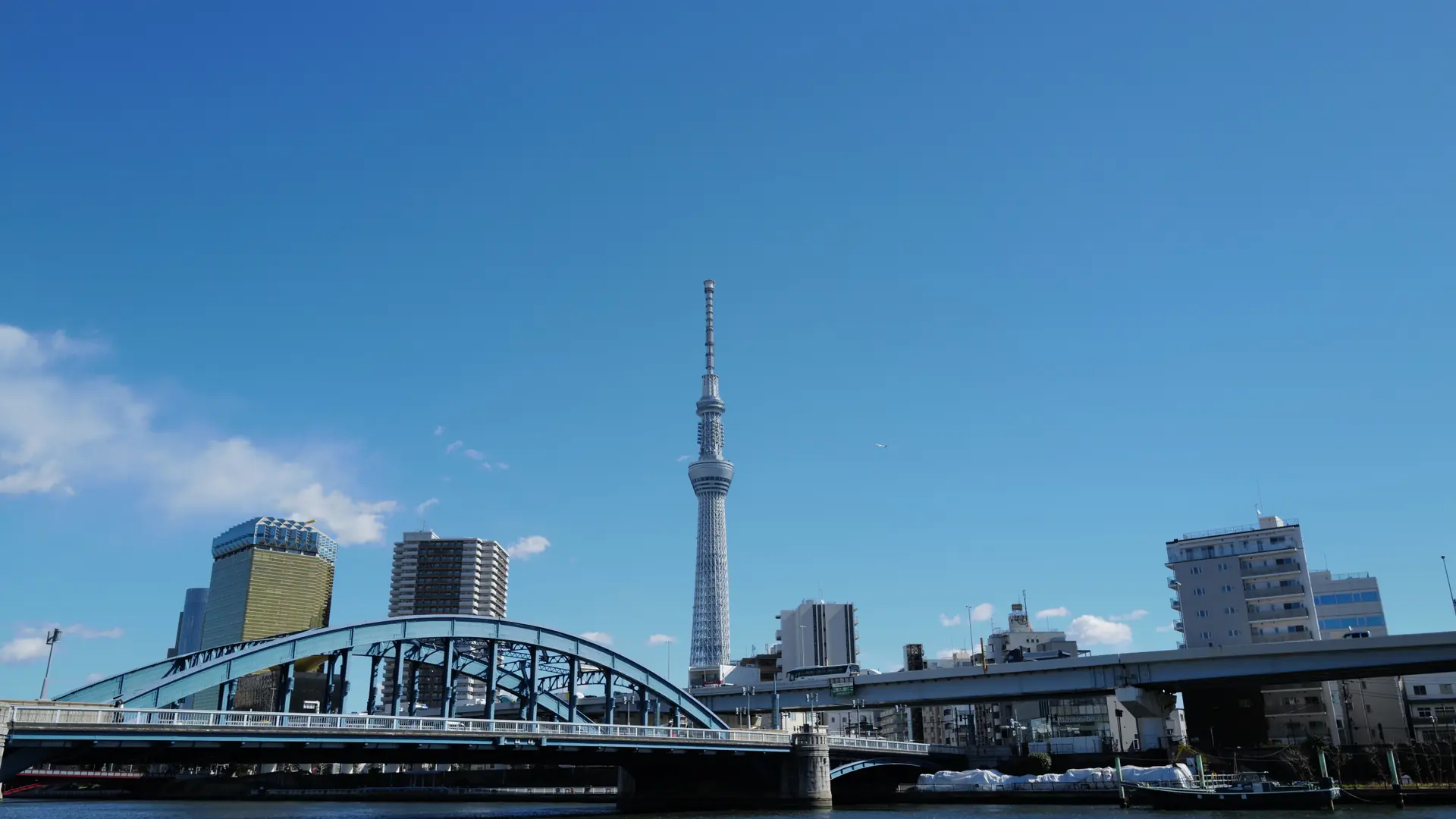 Tokyo's sunlit skyscrapers surrounding the Shibuya district under a clear blue sky
