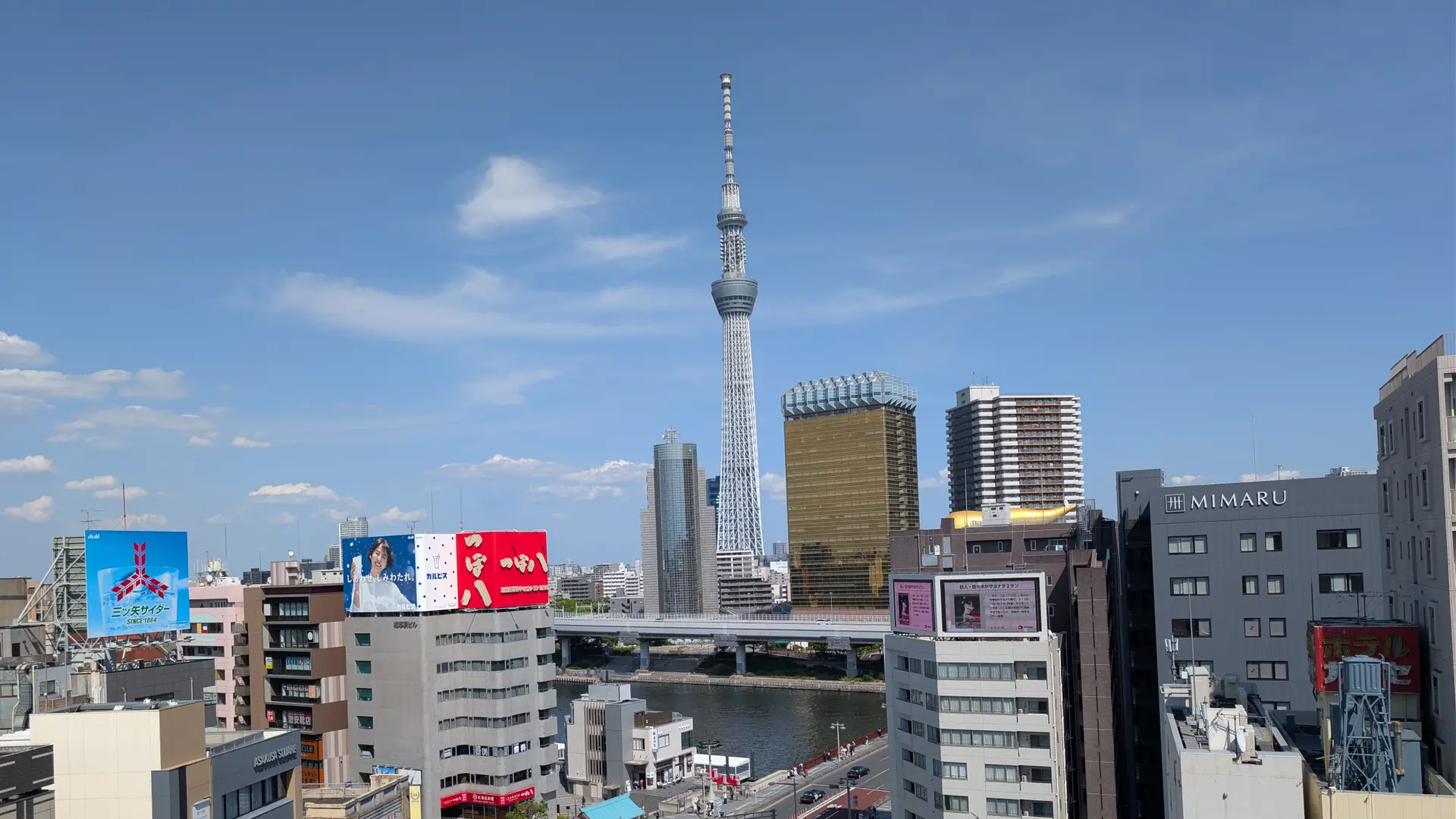 Tokyo Skytree and Asahi’s gold-coloured tower above the Sumida River in sunny Tokyo.