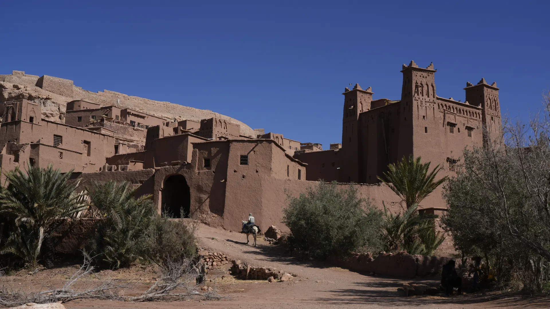Earthen kasbah walls near Ouarzazate beneath a deep blue sky