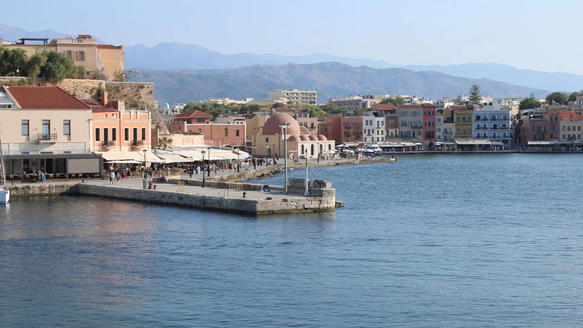 Chania harbour and its waterfront mosque with mountains beyond, shown as a wider city setting