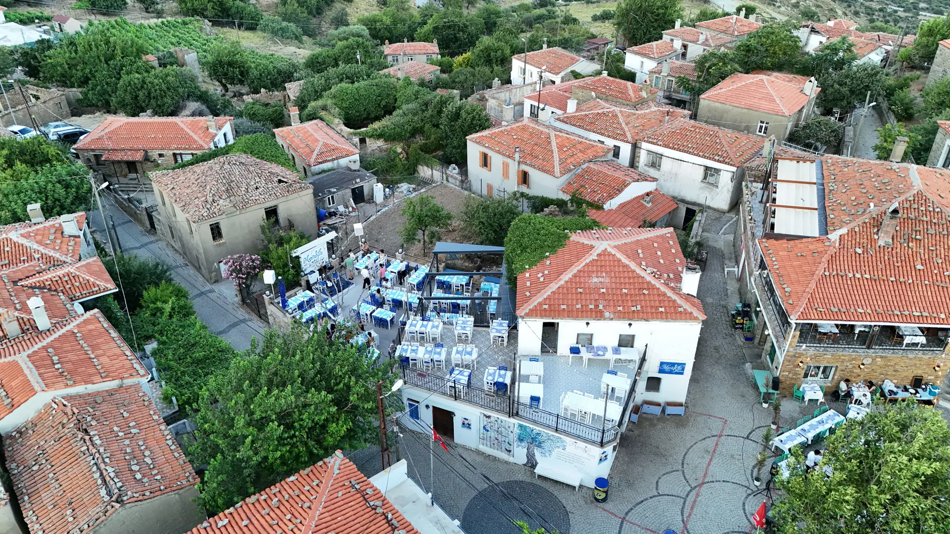Red-roofed village lanes and garden tables on Gökçeada