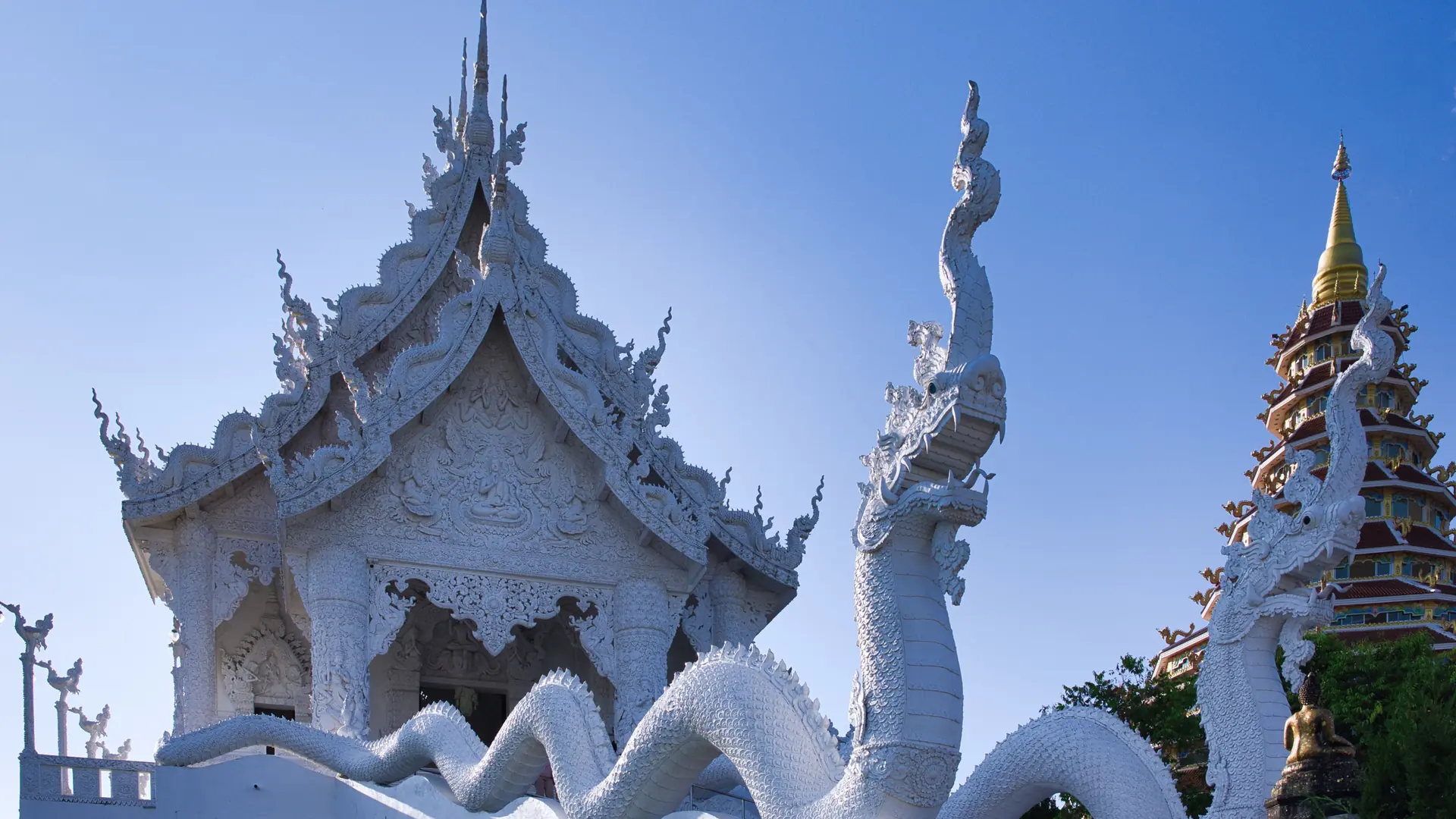 Wat Rong Khun's white carvings and mirrored details shining in Chiang Rai