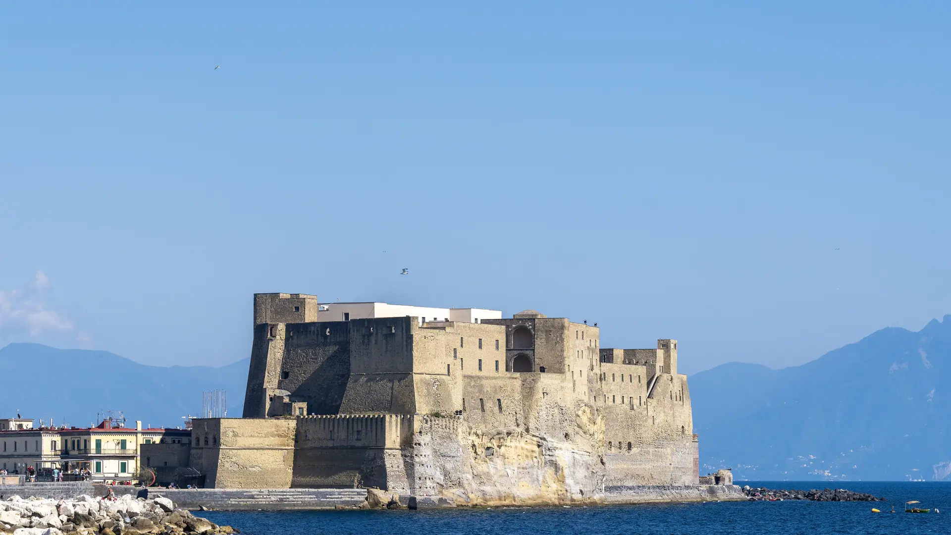 golden Naples waterfront at Santa Lucia with Castel dell’Ovo and calm bay water