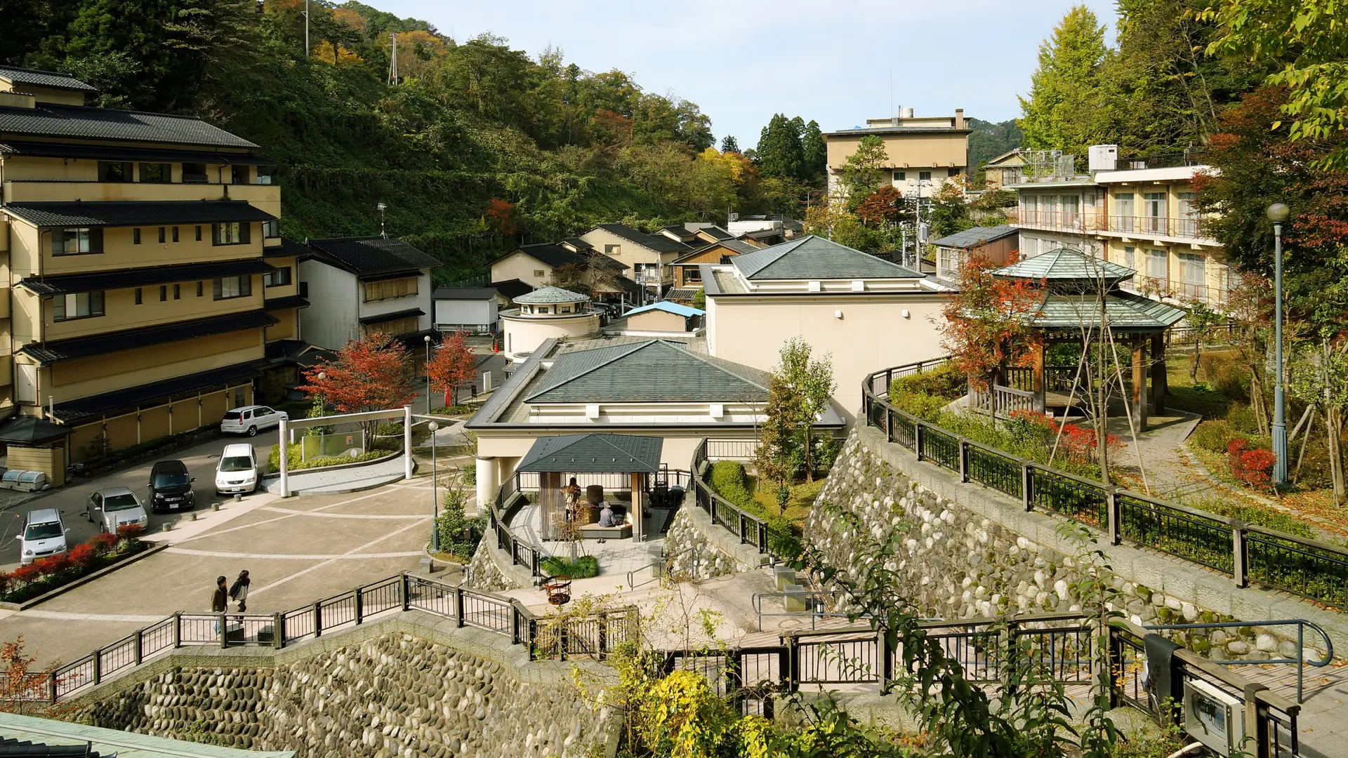 Yuwaku Onsen ryokan buildings surrounded by colourful forested hills in Kanazawa