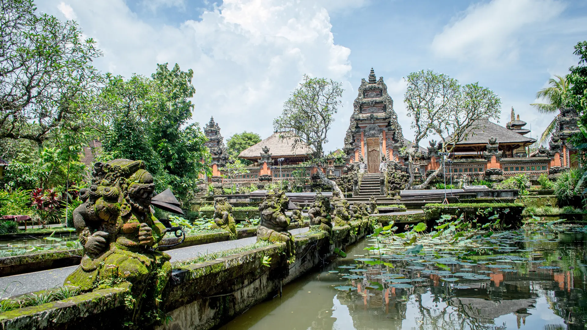 Carved stone figures and a lotus pond at the Ubud Water Palace
