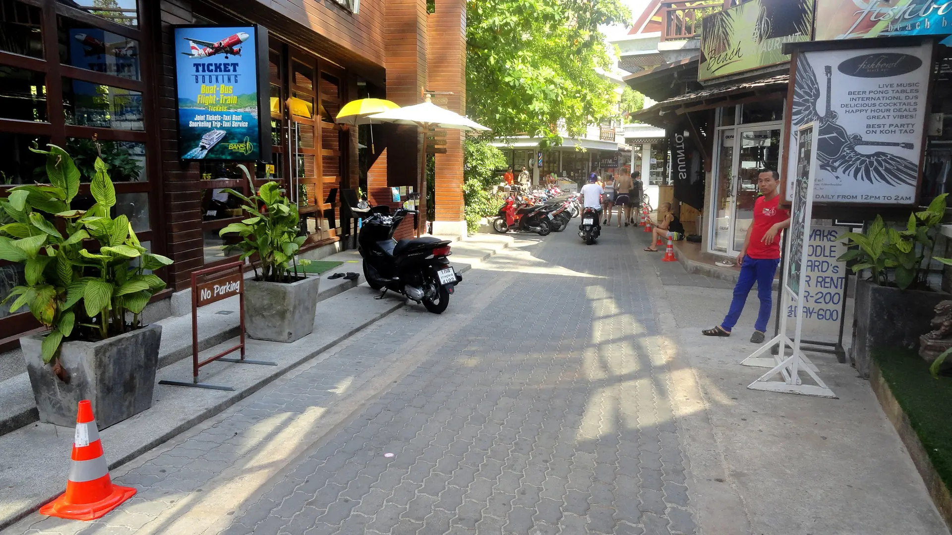A sunlit lane with shops and visitors in Sairee, wider Koh Tao rather than Chalok
