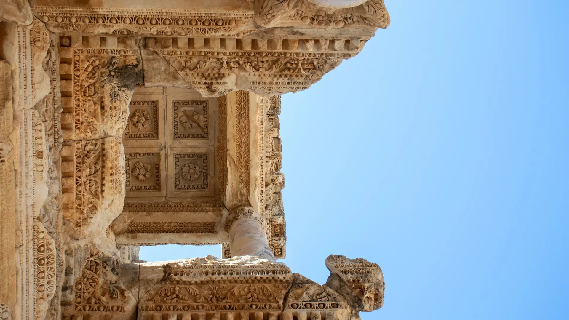 Carved stone arch at Ephesus against a clear blue sky