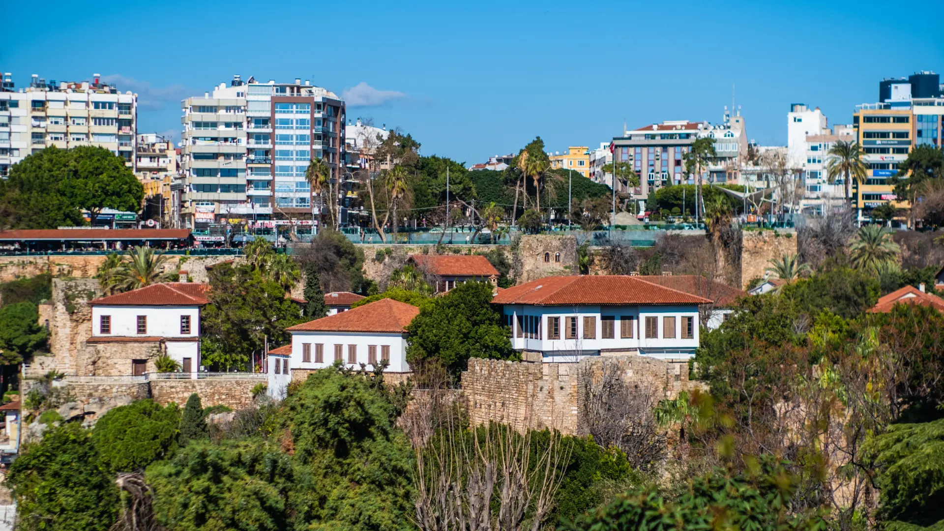 White houses with red roofs above the old harbour cliff in Antalya