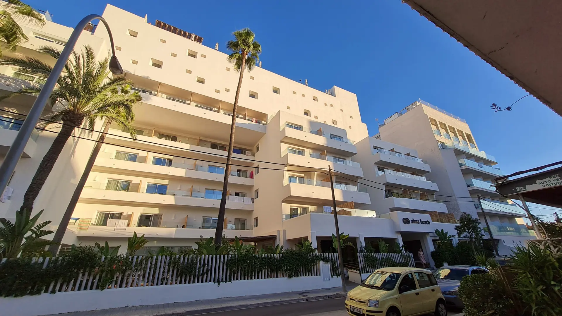 White balconies and palms at the HM Alma Beach hotel frontage in Can Pastilla, Palma